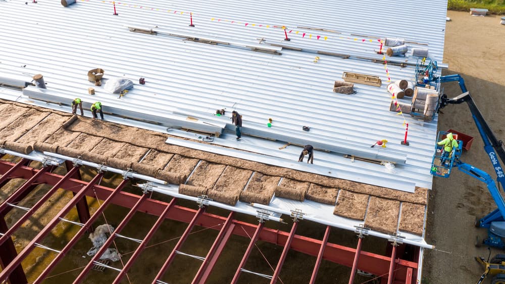 Workers working in a business warehouse roof.